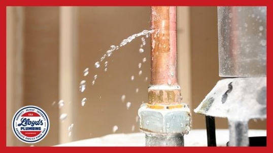 A copper pipe with water spraying out of a puncture spot